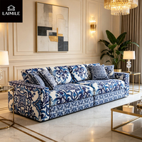 Canapé 3 places en tissu floral bleu et blanc de luxe, style vintage, avec coussins assortis, pour salon de villa.