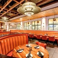 Ensemble de banquettes de restaurant sur mesure UPTOP, canapé en cuir orange, table de bar et ensemble de chaises