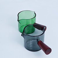 Vaso medidor de vidrio verde de 75 ml / 2.2 oz con un solo mango de madera para extractos de sabor, alimentos, concentrados de café y bebidas espirituosas.