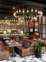 Diseño de Interiores para Restaurantes y Bares Industriales con Muebles Comerciales Personalizados de Metal Negro, Asientos Tipo Cabina y Equipamiento Llave en Mano