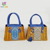 Handgeweven rotan handtas met etnisch geborduurde patch, blauwe leren handvat, stro tas voor zomerse strandvakantie