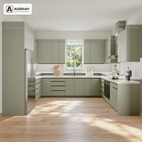 Meuble de cuisine minimaliste en PVC en forme de U avec portes en panneaux vert sauge, boîtes en MDF et poignées intégrées