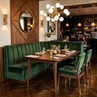 Ensemble de banquettes de restaurant contemporain de luxe avec canapé en cuir capitonné crème et table en marbre blanc avec chaises en velours