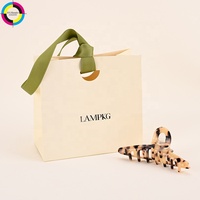 Sacs shopping en papier ivoire personnalisés avec votre propre logo, rubans imprimés noirs, poignées, emballages cadeaux de luxe pour boutiques de détail