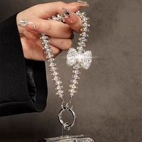 Lanière de téléphone portable avec nœud en perles et strass brillants, chaîne anti-chute, pendentif clé tendance pour femme, petit cadeau à la mode