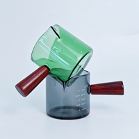 Vaso medidor de vidrio verde de 75 ml / 2.2 oz con un solo mango de madera para extractos de sabor, alimentos, concentrados de café y bebidas espirituosas.