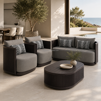 Ensemble de canapés d'extérieur en aluminium gris foncé de luxe moderne, table basse ovale cannelée, fauteuils cylindriques confortables pour cour et patio
