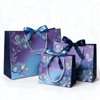 Sac cadeau en papier imprimé sur mesure, motif floral dégradé argenté, avec poignées en ruban de satin et nœud, pour mariage, fête prénuptiale, ou comme sac fourre-tout pour cadeaux.