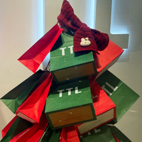 Sacs en papier kraft empilés de manière créative en forme de sapin de Noël, ajoutant une touche festive à l'affichage des magasins de vêtements