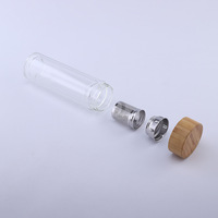 Fabricant de bouteilles en verre à double paroi avec logo personnalisé, vendant des bouteilles d'eau avec infuseur à thé et fruits, avec couvercle en bambou