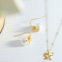 Collier fantaisie plaqué or avec pendentif nœud papillon rond et perles imitation de haute qualité – Accessoires de mode pour femme en gros