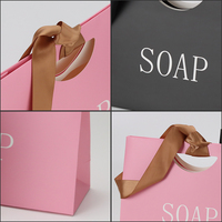 Sac shopping en papier personnalisé avec ruban satiné assorti et poignée perforée pour l'emballage de produits cosmétiques, de soins de la peau et de cadeaux
