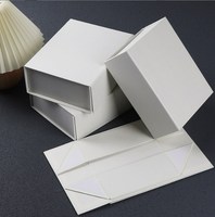 Boîte cadeau rigide pliable noire de luxe avec logo personnalisé, fermeture magnétique, ruban, gaufrage, pelliculage mat, matériaux recyclés, taille personnalisée