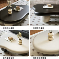 Table basse élégante et unique de style minimaliste nordique, couleur crème, avec base en boule noire