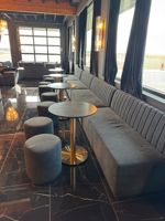 Projet de rénovation de restaurant haut de gamme : table ronde en marbre demi-cercle, mobilier de restaurant, ensemble de canapés et banquette.