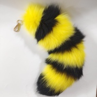 Pendentif en fourrure de queue de renard rayé jaune citron et noir, accessoire de sac à dos, un incontournable pour les créateurs de tendances.