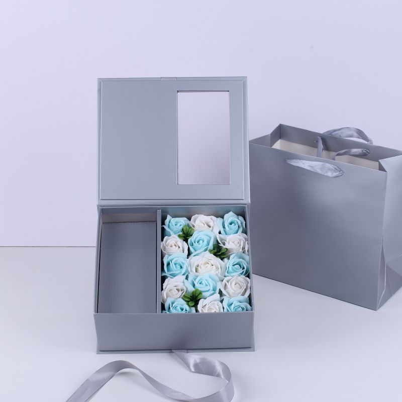 Boîte d'emballage grise avec sac à main et fleur