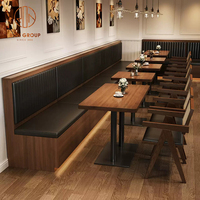 Ensemble de mobilier pour café-restaurant : tables carrées en bois avec base métallique, chaises en rotin à dossier en bois et banquette.