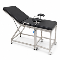 Table d'examen gynécologique en acier inoxydable pour centre médical avec supports de jambes rembourrés et structure stable