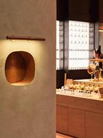 Comptoir de présentation de parfums en marbre au design intérieur unique pour parfumerie, armoire à parfums cintrée en placage de bois