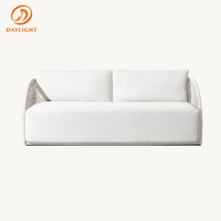 Ensemble de salon de jardin de luxe en corde tressée, chaises longues incurvées en osier avec coussins blancs aspect pierre pour piscine, villa, complexe hôtelier