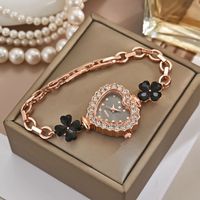 Montre pour femme élégante et chic de style luxe léger, avec chaîne à motif trèfle à quatre feuilles et quartz en forme de cœur