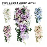 Élégant bouquet de mariée en cascade en forme de larme avec des fleurs de pivoine lilas, violettes et blanches, et des feuillages mélangés, pour la décoration de cérémonie de mariage