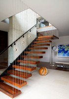 Escalier flottant intérieur en bois avec contremarche invisible murale et balustrade en verre