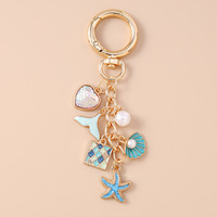 Nouveau porte-clés élégant en forme de coquillage, de queue de poisson et d'étoile de mer avec des perles et un charme en forme de cœur