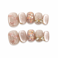 Faux ongles autocollants œil de chat courts et ronds rose nude, avec nœud papillon peint à la main et strass, vente en gros pour femmes