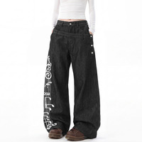 Jean déstructuré à taille asymétrique et boutonnage, avec broderie lourde de notes de musique sur portes-staves, coupe ample et fluide, pantalon long droit