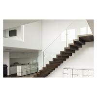 Escalier moderne à double poutre, avec poutres en acier jumelées, remplissage en panneaux de verre, configuration à montantes ouvertes, marches en chêne