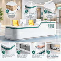 Comptoir d'accueil moderne blanc pour hôpital, avec coins arrondis, bordure verte et plateau de travail haut/bas