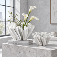 Vase en céramique blanche avec un design sculptural fluide pour fleurs et décoration intérieure