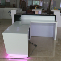 Comptoir de réception en L sur mesure avec éclairage LED, comptoir moderne en surface solide pour hall d'hôtel ou bureau