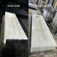 Vasque de salle de bain de luxe translucide rétroéclairée en pierre de cristal blanche pour villa et hôtel