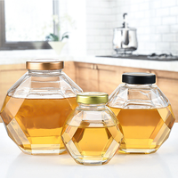 Pot à miel en verre hexagonal en gros avec cuillère en bois et couvercle en liège pour le stockage du miel et du sirop en forme de ruche
