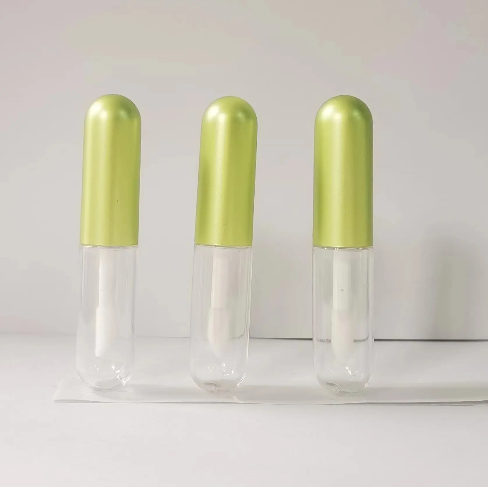 Jinlan tabung Lip Gloss Mini bentuk pil kosong dengan tutup hijau logam tabung Lip Gloss kustom diskon besar transparan