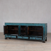 Armoire de rangement en bois massif vieilli et patiné pour un salon de style rétro et vintage, meuble de présentation pour maison d'hôtes.