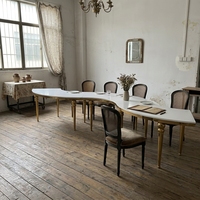 Table à manger de luxe moderne en forme de S avec pieds dorés, structure en acier inoxydable et plateau en marbre pour hôtels et mariages