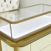 Vitrine de présentation de bijoux de luxe sur pied en verre trempé avec éclairage LED intégré, finition dorée, noir brillant, pour la vente au détail