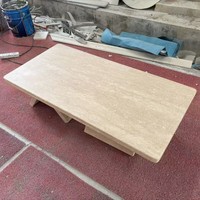 Table basse moderne en travertin naturel, table centrale en pierre beige naturelle avec base géométrique pour la décoration du salon