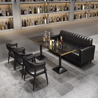 Ensemble de table à manger rectangulaire moderne avec fauteuils rembourrés noirs, plateau aspect pierre brillant et base sur piétement, pour restaurant et café