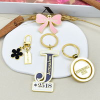 Großhandel Vergoldete Emaille-Schlüsselanhänger mit Schleifen- und Blumenmuster-Designs, Runde Schlüsselringe 360 ° Rotierender Metall-Schlüsselanhänger