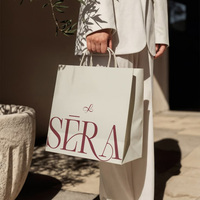 Sac cadeau en papier blanc mat personnalisé avec poignée en ruban satiné, logo or rose pour l'emballage des cliniques de beauté et des salons