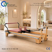 Reformer de Pilates en bois de chêne rose poussiéreux avec barre de pieds intégrée et barre spécialisée pour cours de bien-être en boutique