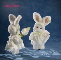 Adorable lapin en peluche blanc sur le thème du printemps avec robe en dentelle et tulipe