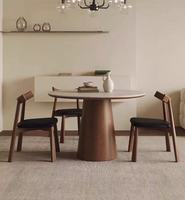 Ensemble de table à manger ronde en bois massif de style nordique avec plateau en pierre frittée effet marbre et chaises confortables en cuir pour appartement