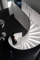 Escalier hélicoïdal incurvé minimaliste sur mesure Tanlong, marches en marbre veiné noir et en chêne clair, panneau massif incurvé