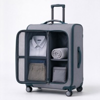 Valise à roulettes souple grise et turquoise avec compartiment avant zippé, deux poches en filet et poignée télescopique